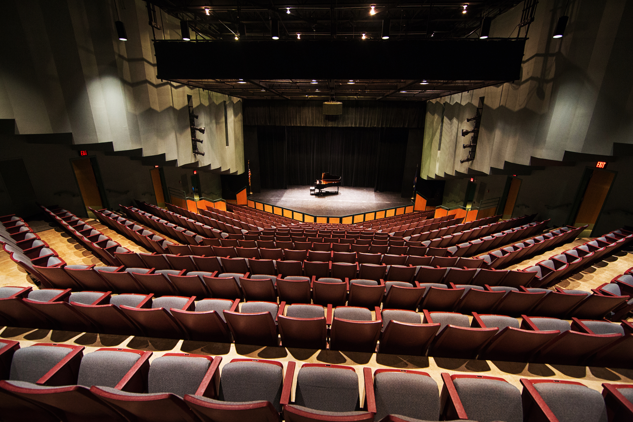 Picture of theatre seats  in Dickinson Theater looking downward at a stage with a grand piano