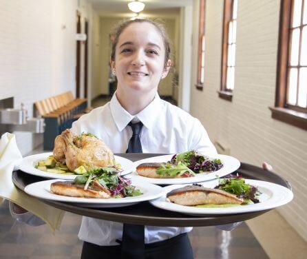 A student holding plates of food