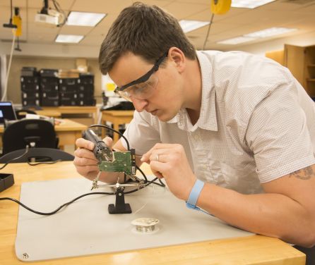 Student wearing protective glasses working on a lab project