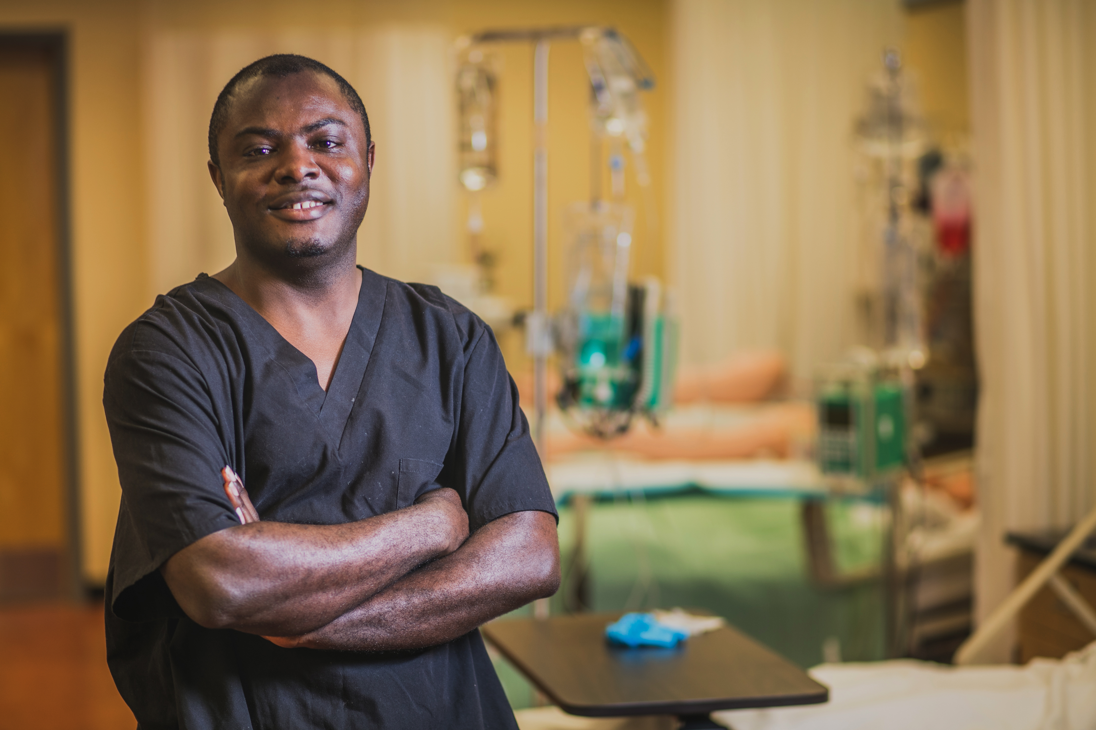 Employee wearing scrubs in hospital room.